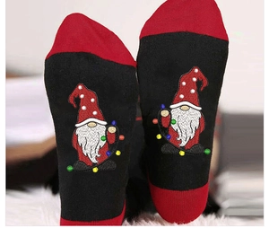 Macro detail of Christmas gnome embroidery with colorful lights on black cotton socks