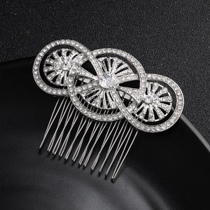 Detailed close-up of a silver bridal hair comb with rhinestones on a black background