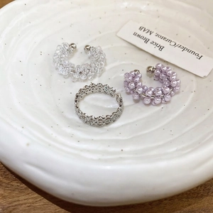 Elegant floral beaded pearl ear cuff and ring set in a minimalist ceramic display