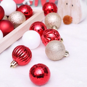 Assorted red and gold Christmas ball ornaments set on a wooden tray with plush background