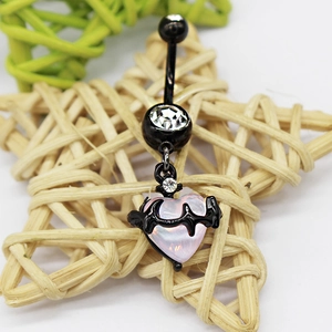 Detail of black heart-shaped belly ring with pink glass stone on a woven star background