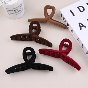 Detail view of four large flocked hair claws in brown, wine red, coffee, and black tones