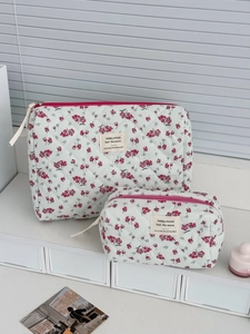 Macro view of floral corduroy makeup bags with quilted texture and red zipper details