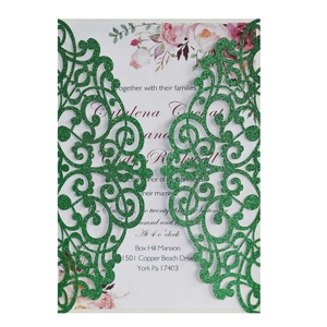 Detail of green glitter laser-cut wedding invitation with elegant floral printed insert