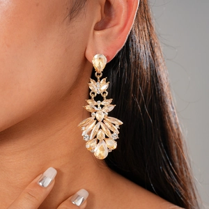 Macro shot of luxury champagne teardrop earrings with crystals and gold finish