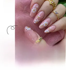 Detail of almond-shaped nails featuring daisy patterns and tiny bee art accents