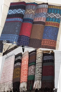 Detailed close-up of bohemian style jacquard patterns and soft tassels on woven shawls