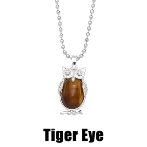Detailed view of silver owl pendant featuring a polished tiger eye stone inlay