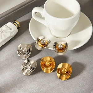 Close-up of irregular oval stainless steel earrings in gold and silver finishes