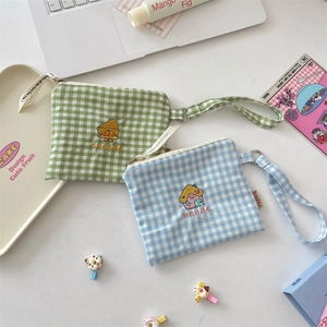 Detailansicht der Gingham-Aufbewahrungstaschen mit Käse- und Haus-Stickerei-Details