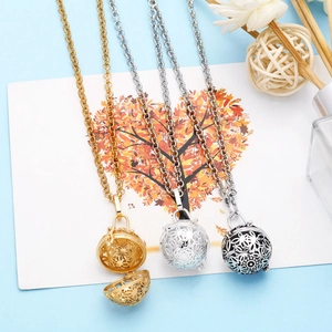 Detailed view of three openable hollow globe pendants in gold, silver, and black finishes