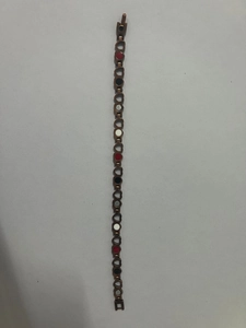 Detail of magnetic heart link bracelet featuring inlaid red black and white decorative stones