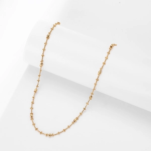 Detailed macro view of thin gold-plated S925 sterling silver chain with small bead accents