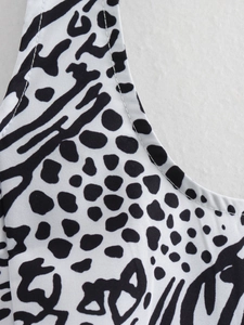 Gedetailleerde macro-opname van de ronde hals met zwart-witte dierenprint op deze top