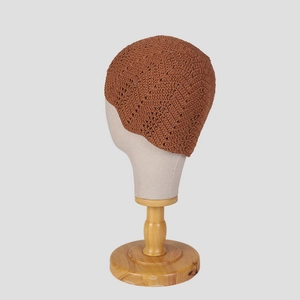 Detailed view of handmade crochet beanie with vintage floral hollow pattern and brown knit