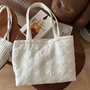 White quilted shell-pattern tote bag with embroidered details and spacious interior