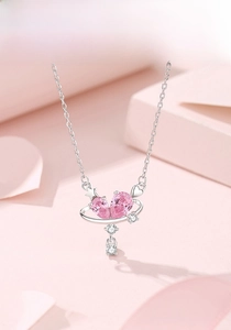 Close-up of S925 silver heart necklace with pink zircons and planet ring detail