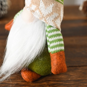 Close-up of a green Nordic Christmas gnome featuring a white beard and knit hat decoration