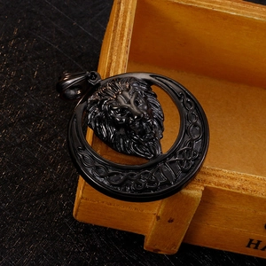 Detailed view of a black lion head pendant with Celtic knot patterns on a wooden surface