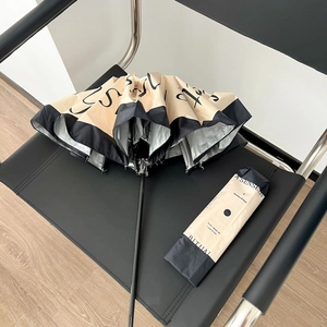 Detail of minimalist beige and black umbrella with sun-protective silver coating and fabric sleeve