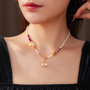 Detail of vintage flower basket pendant necklace with colorful beads and Fu charm