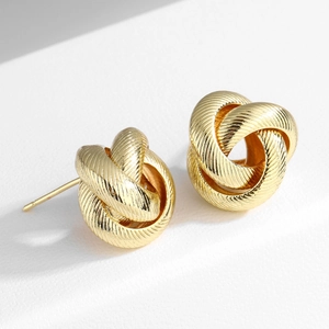 Elegant gold twisted knot earrings with textured metallic finish on white background