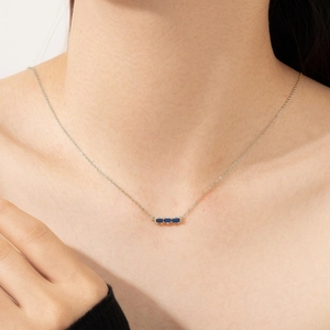 Detail of elegant silver necklace featuring three blue rectangular gemstones and diamonds
