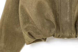 Dettaglio della giacca bomber in finta pelle scamosciata oliva con texture del tessuto