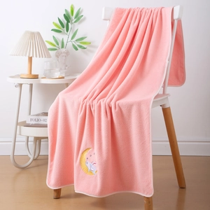 Detail of pink coral fleece towel featuring cute embroidered moon and unicorn design