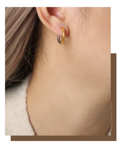Macro shot of a mixed-tone geometric hammered earring worn on a female ear model