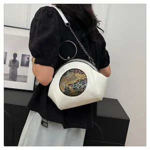 Detail of white vintage shell bag with retro elephant relief and metallic chain strap