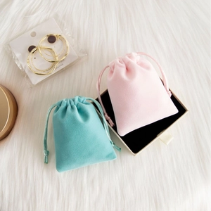 Pink and blue plush velvet drawstring jewelry pouches with S925 earrings on faux fur