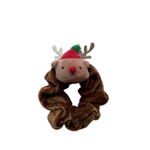 Détail d'un chouchou renne en peluche avec velours marron et design de bois de Noël