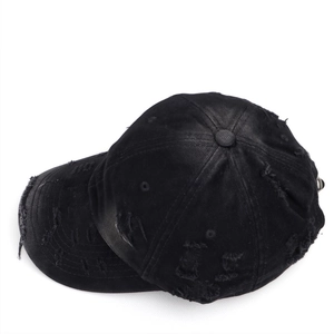 Detailed close-up of distressed vintage baseball cap with ripped holes and metal ring