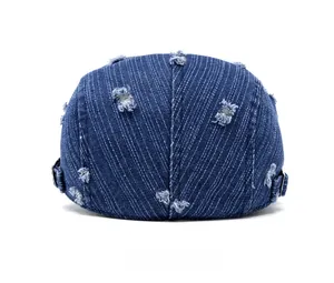 Detail view of the adjustable metal buckle and distressed denim fabric on the beret hat