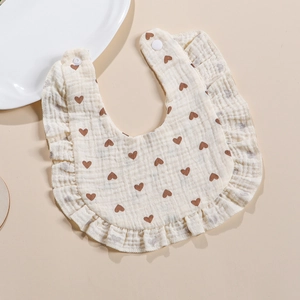 Muslin cotton baby bib with ruffles and heart print featuring adjustable snap buttons
