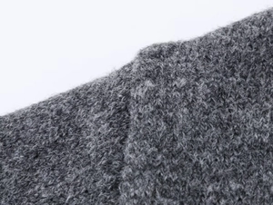 Close-up of gray knitted cardigan fabric with plush texture and detailed wool fibers