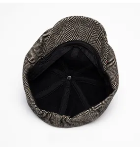 Detail view of newsboy cap interior showing black lining and herringbone tweed fabric