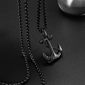 Macro shot of black anchor pendant with rope details and steel box chain