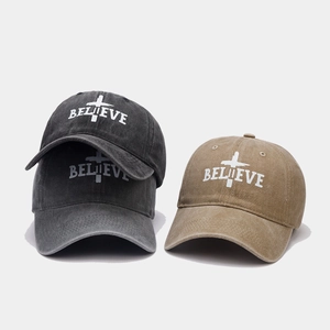 Detail of BELIEVE cross embroidery on vintage washed cotton baseball cap texture