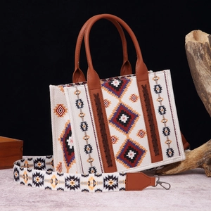Detail of bohemian tote bag with ethnic print, woven texture and brown leather handles