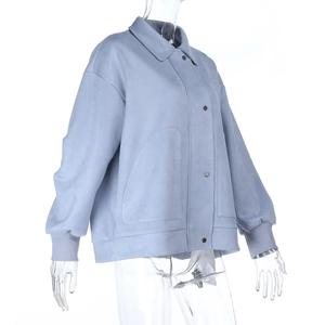 Detail of blue faux suede jacket featuring metal buttons and ribbed knit cuffs