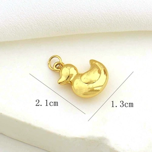 Detailed size view of a golden duck charm measuring 2.1cm by 1.3cm on a textured stone surface