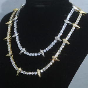 Detail of silver and gold 5mm tennis chains with iced out spike pendants on black mannequin