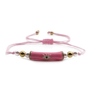 Pink evil eye bracelet with pearl accents and adjustable woven cord on white background