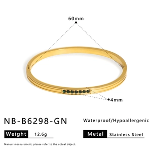Detail of 60mm golden stainless steel bangle featuring green zircon stone inlay