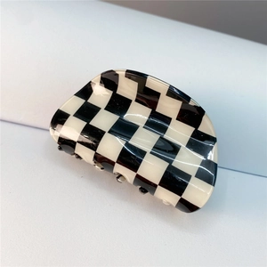Macro shot of large black and white checkerboard hair claw clip with glossy finish