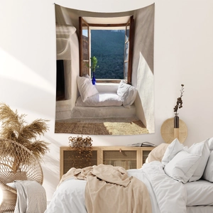 Detail of bohemian tapestry featuring a Mediterranean window view over a bed