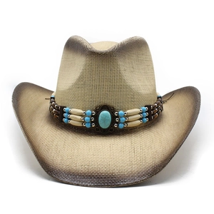 Détail d'un chapeau de cowboy en paille tressée avec perles turquoise et pierre