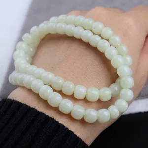 Natural light green Hetian jade round beads for DIY jewelry making held in hand